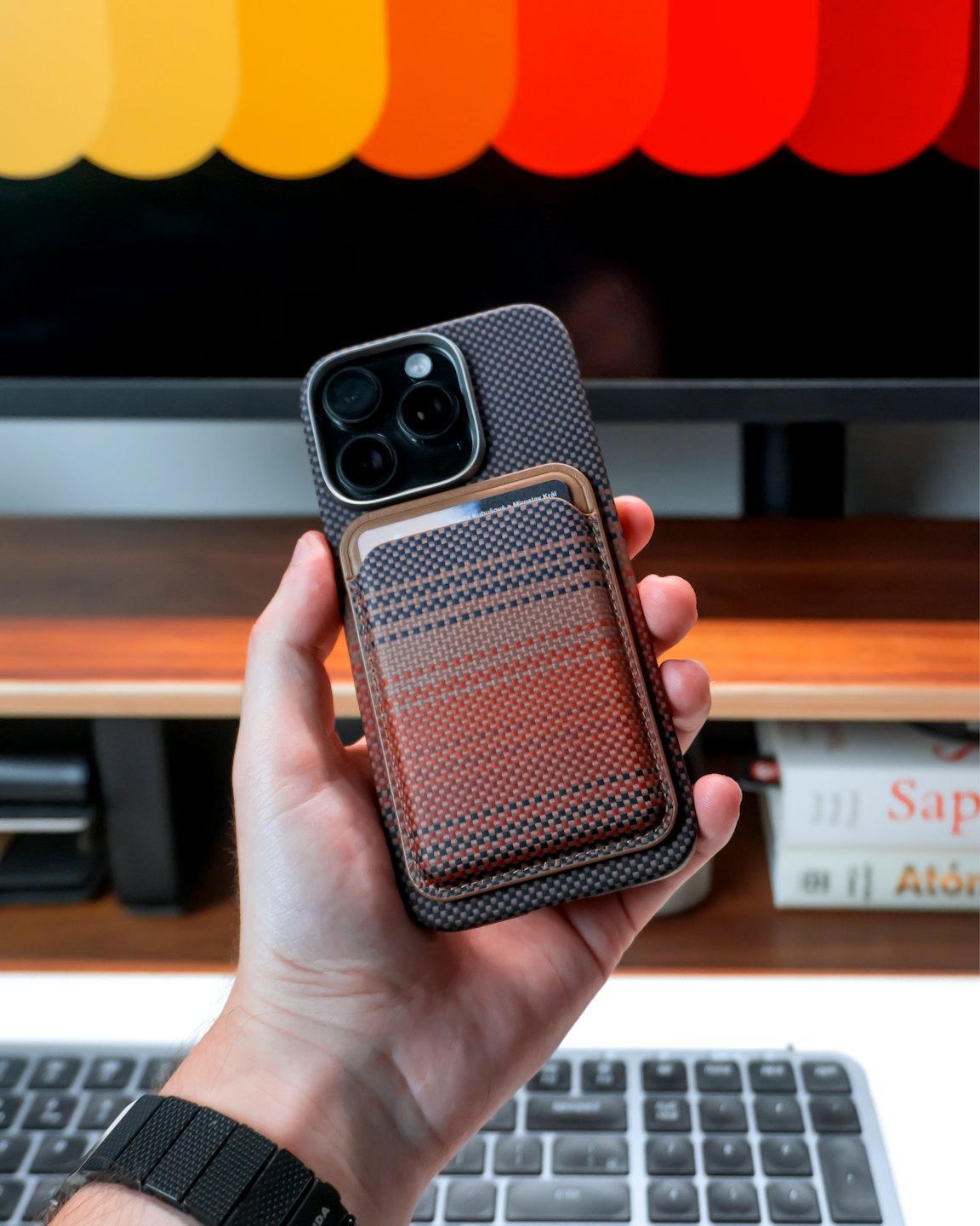 Eine Hand hält ein Smartphone mit einem angebrachten Portemonnaie.
